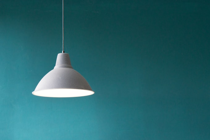 Brass pendant light over a styled interior